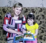 Трунина Ангелина с мамой читают книгу о природе.